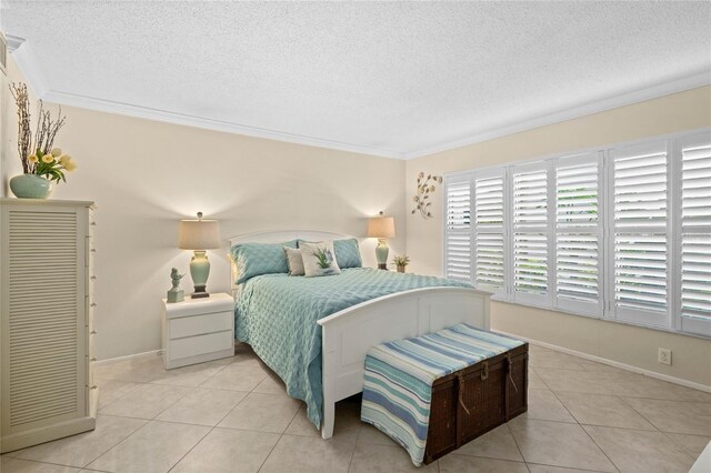 1001 Benjamin Franklin Dr Unit 106, Sarasota, FL 34236 - bedroom with a textured ceiling, ornamental molding, light tile patterned flooring, and baseboards