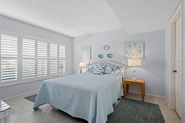 1001 Benjamin Franklin Dr Unit 106, Sarasota, FL 34236 - bedroom featuring light tile patterned floors, a textured ceiling, and baseboards
