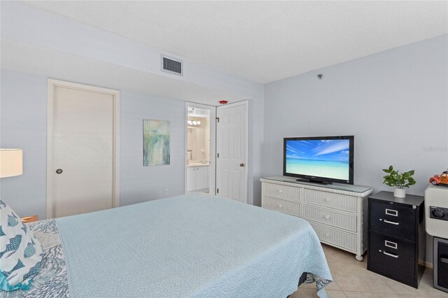 1001 Benjamin Franklin Dr Unit 106, Sarasota, FL 34236 - bedroom featuring light tile patterned floors and ensuite bath