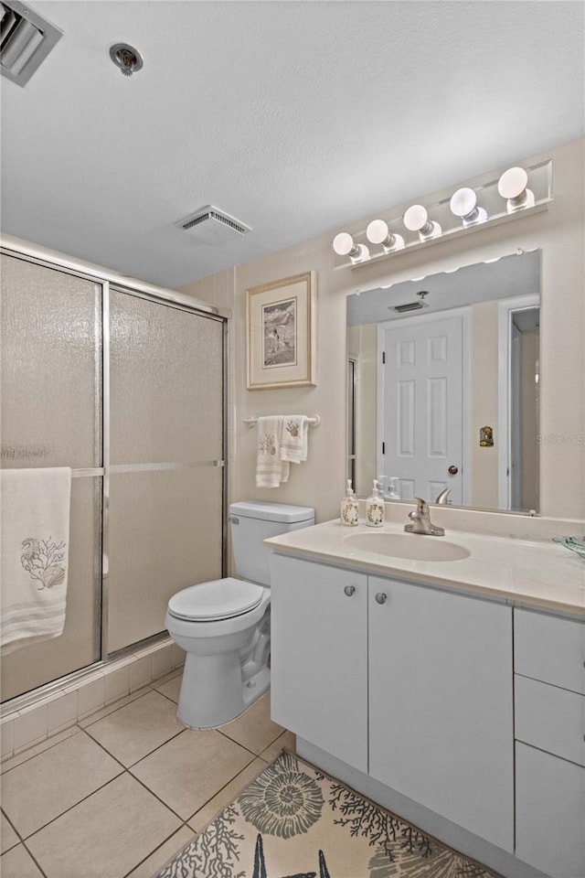 1001 Benjamin Franklin Dr Unit 106, Sarasota, FL 34236 - full bathroom featuring vanity, toilet, tile patterned flooring, and a shower stall