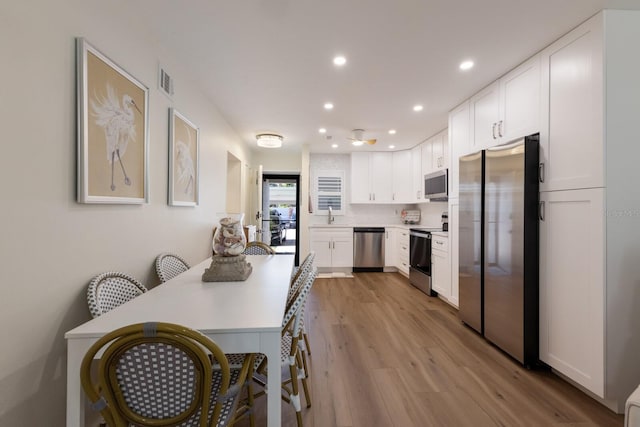 5623 Midnight Pass Rd Unit 615, Sarasota, FL 34242 - kitchen with appliances with stainless steel finishes, white cabinets, wood finished floors, recessed lighting, and light countertops
