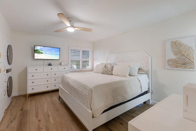5623 Midnight Pass Rd Unit 615, Sarasota, FL 34242 - bedroom featuring stacked washing machine and dryer, light wood-style flooring, a ceiling fan, and baseboards