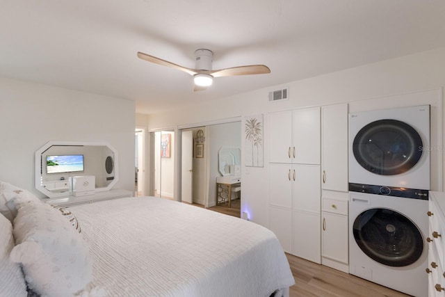 5623 Midnight Pass Rd Unit 615, Sarasota, FL 34242 - bedroom with stacked washer / drying machine, light wood-style flooring, ceiling fan, and two closets