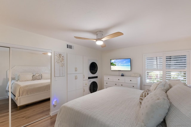 5623 Midnight Pass Rd Unit 615, Sarasota, FL 34242 - bedroom featuring stacked washer / dryer, light wood-type flooring, and a ceiling fan