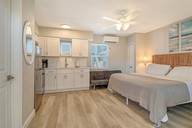 105 Casey Key Rd Unit 20, Nokomis, FL 34275 - bedroom featuring a wall mounted air conditioner, light wood finished floors, a sink, and ceiling fan