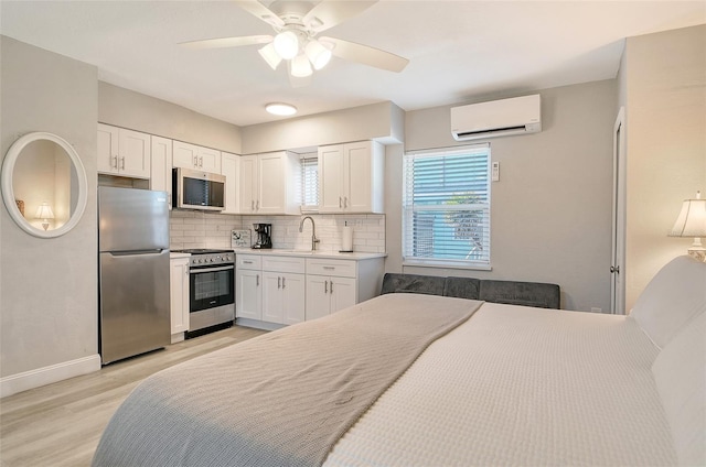 105 Casey Key Rd Unit 20, Nokomis, FL 34275 - bedroom featuring freestanding refrigerator, a wall mounted AC, light wood-type flooring, baseboards, and a sink