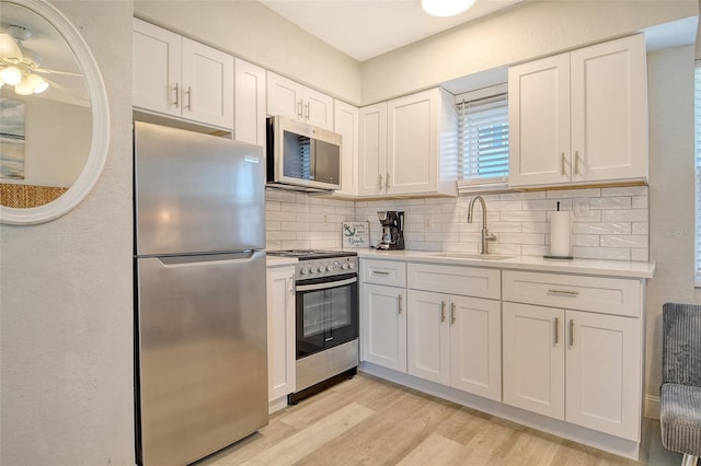 105 Casey Key Rd Unit 20, Nokomis, FL 34275 - kitchen featuring appliances with stainless steel finishes, a sink, white cabinetry, tasteful backsplash, and light countertops