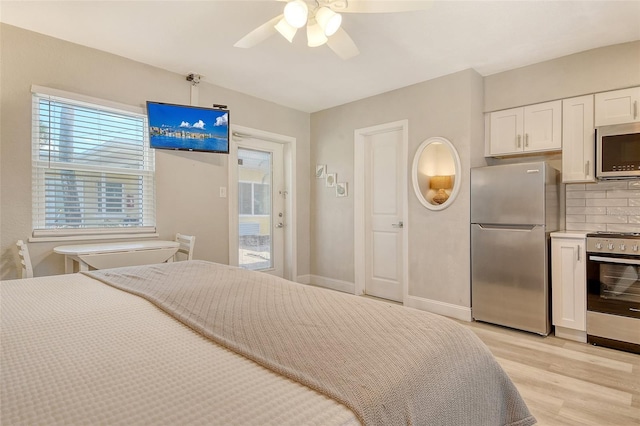 105 Casey Key Rd Unit 20, Nokomis, FL 34275 - bedroom with freestanding refrigerator, light wood-style flooring, ceiling fan, access to exterior, and baseboards
