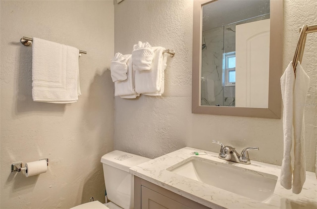105 Casey Key Rd Unit 20, Nokomis, FL 34275 - bathroom featuring toilet, a marble finish shower, vanity, and a textured wall