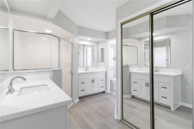 251 Broadmoor Ln, Rotonda West, FL 33947 - full bathroom featuring wood finished floors, two vanities, toilet, baseboards, and recessed lighting
