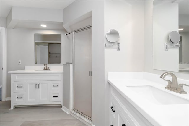 251 Broadmoor Ln, Rotonda West, FL 33947 - bathroom with a stall shower, two vanities, wood finished floors, and recessed lighting