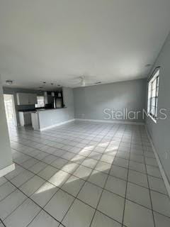 unfurnished living room featuring tile patterned floors and baseboards