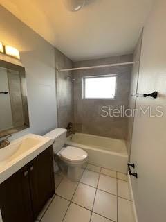 bathroom featuring tile patterned floors, vanity, toilet, and shower / bathtub combination