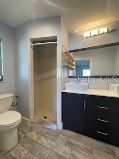 full bathroom featuring a stall shower, toilet, vanity, and baseboards