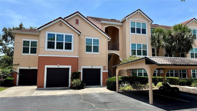 4142 Central Sarasota Pkwy Unit 1423, Sarasota, FL 34238 - view of property featuring stucco siding, a garage, a tile roof, and driveway