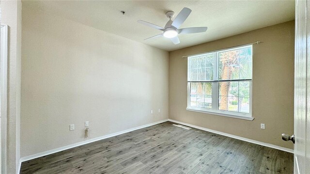 4142 Central Sarasota Pkwy Unit 1423, Sarasota, FL 34238 - empty room with wood finished floors, plenty of natural light, baseboards, and a ceiling fan