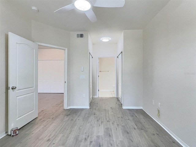 4142 Central Sarasota Pkwy Unit 1423, Sarasota, FL 34238 - unfurnished bedroom featuring light wood-style floors, baseboards, a ceiling fan, and connected bathroom