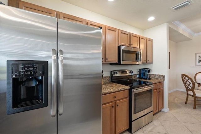 7005 River Hammock Dr Unit 203, Bradenton, FL 34212 - kitchen featuring appliances with stainless steel finishes, light tile patterned floors, dark stone counters, recessed lighting, and baseboards