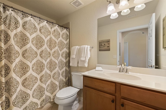 7005 River Hammock Dr Unit 203, Bradenton, FL 34212 - full bathroom featuring toilet, vanity, a textured wall, and tile patterned floors