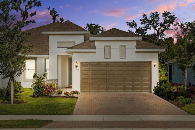5816 Mezzana Run, Palmetto, FL 34221 - view of front of house featuring stucco siding, an attached garage, decorative driveway, and roof with shingles