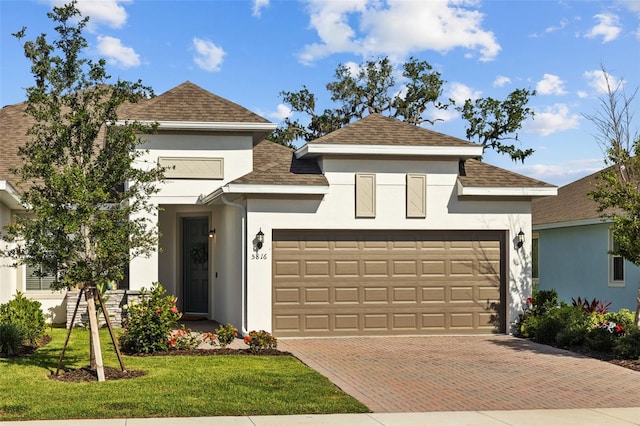 5816 Mezzana Run, Palmetto, FL 34221 - view of front of home featuring stucco siding, a shingled roof, a garage, and decorative driveway