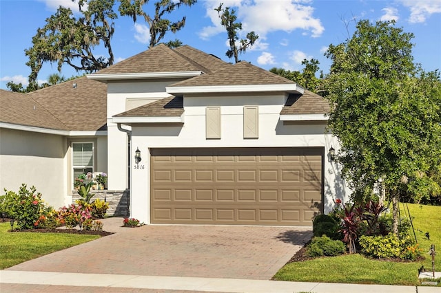 5816 Mezzana Run, Palmetto, FL 34221 - view of front of home featuring stucco siding, an attached garage, decorative driveway, roof with shingles, and a front lawn