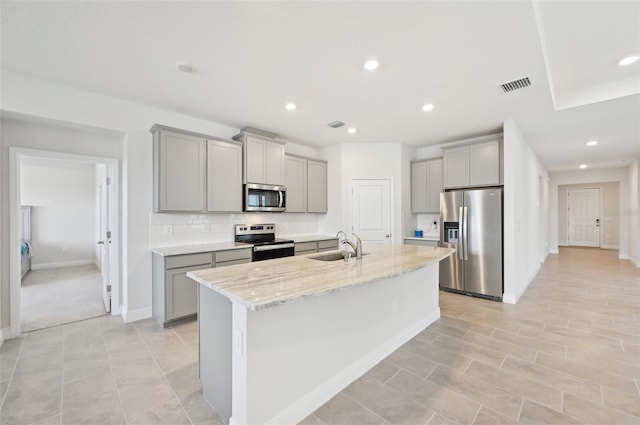 kitchen with stainless steel appliances, gray cabinets, a sink, backsplash, and recessed lighting