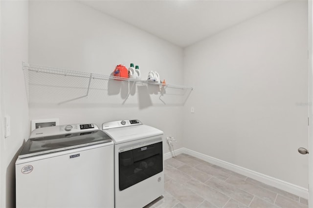 laundry room featuring washer and clothes dryer and baseboards