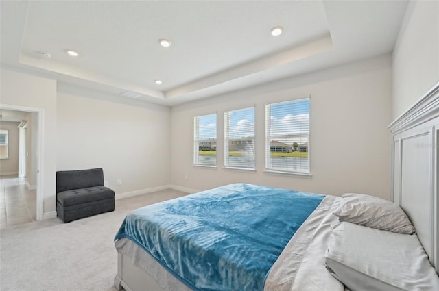 bedroom featuring a raised ceiling, light carpet, recessed lighting, and baseboards