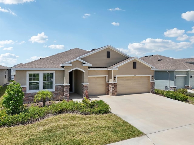 view of front of home with stone siding, an attached garage, stucco siding, driveway, and a front yard