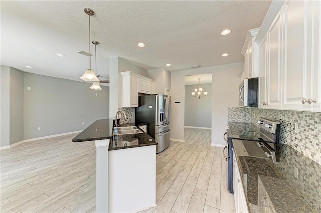 11811 Fennemore Way, Parrish, FL 34219 - kitchen with appliances with stainless steel finishes, a sink, light wood-style flooring, white cabinets, and decorative backsplash