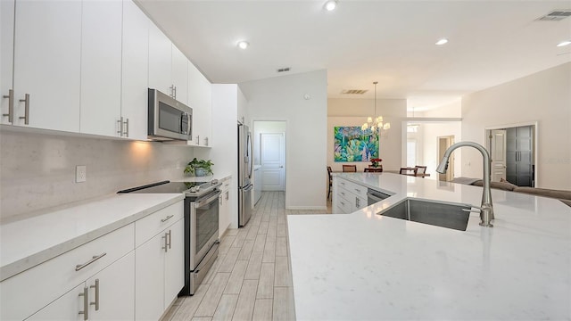 6721 Oak Manor Dr, Lakewood Ranch, FL 34202 - kitchen with appliances with stainless steel finishes, a sink, a chandelier, pendant lighting, and white cabinets