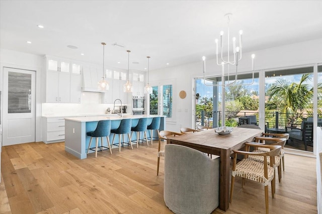 dining space featuring a chandelier, light wood-type flooring, and recessed lighting