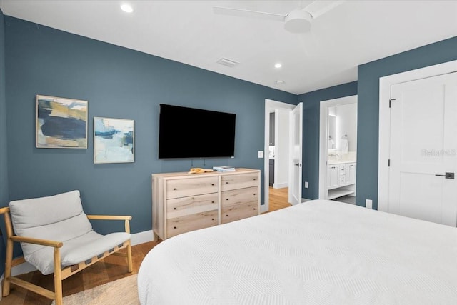 bedroom featuring wood finished floors, baseboards, recessed lighting, ensuite bathroom, and a ceiling fan