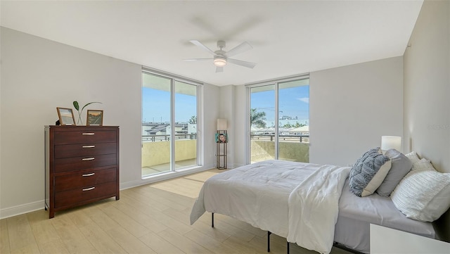 800 N Tamiami Trl Unit 317, Sarasota, FL 34236 - bedroom with floor to ceiling windows, access to outside, light wood-style floors, baseboards, and a ceiling fan