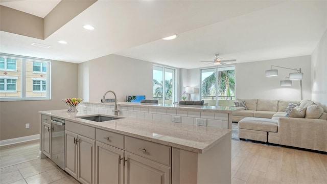 800 N Tamiami Trl Unit 317, Sarasota, FL 34236 - kitchen with stainless steel dishwasher, a sink, open floor plan, a kitchen island with sink, and a ceiling fan