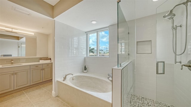 800 N Tamiami Trl Unit 317, Sarasota, FL 34236 - full bathroom featuring a stall shower, a garden tub, vanity, and tile patterned flooring