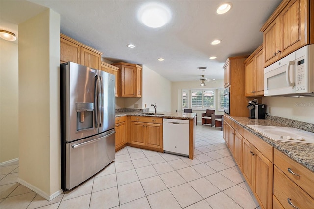 3335 Meadow Run Ter, Venice, FL 34293 - kitchen with stainless steel appliances, a sink, a peninsula, recessed lighting, and light tile patterned floors