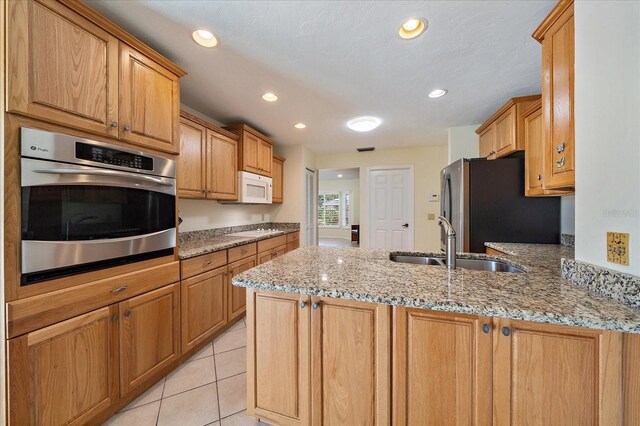 3335 Meadow Run Ter, Venice, FL 34293 - kitchen with appliances with stainless steel finishes, a sink, a peninsula, light stone countertops, and recessed lighting
