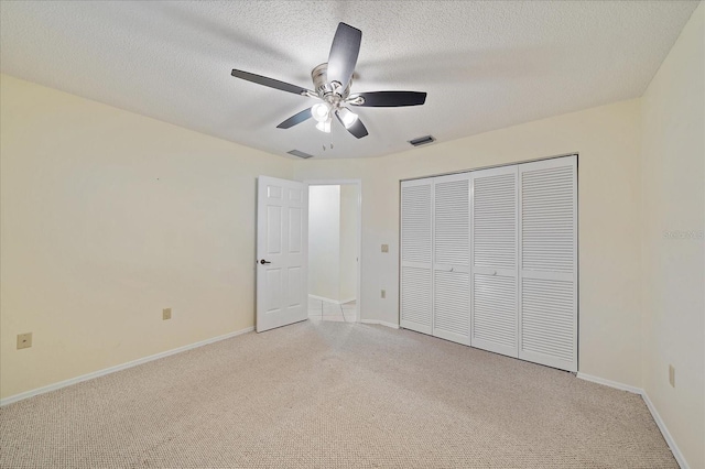 3335 Meadow Run Ter, Venice, FL 34293 - unfurnished bedroom featuring light colored carpet, a closet, baseboards, a textured ceiling, and ceiling fan