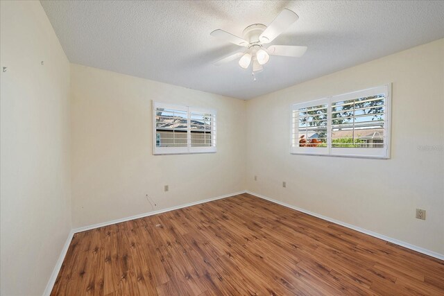 3335 Meadow Run Ter, Venice, FL 34293 - empty room with plenty of natural light, wood finished floors, baseboards, a textured ceiling, and a ceiling fan