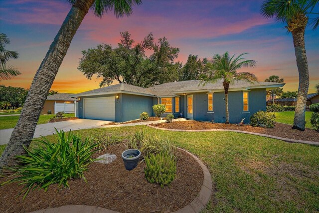3335 Meadow Run Ter, Venice, FL 34293 - view of front of home featuring an attached garage, stucco siding, a lawn, and driveway