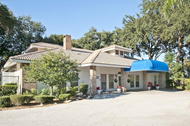 5812 Garden Lakes Fern, Bradenton, FL 34203 - back of house with a tile roof, a chimney, stucco siding, and french doors
