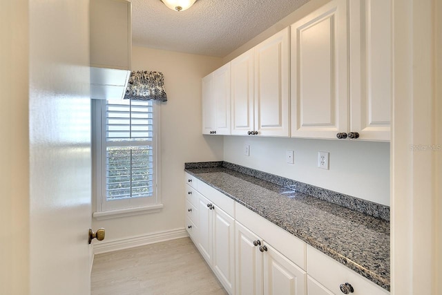 5812 Garden Lakes Fern, Bradenton, FL 34203 - kitchen with plenty of natural light, a textured ceiling, light wood-style flooring, and white cabinets