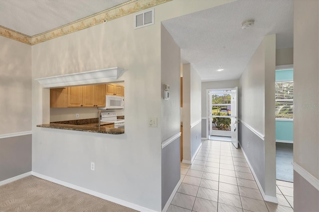 8755 Olde Hickory Ave Unit 7105, Sarasota, FL 34238 - kitchen with white appliances, baseboards, a textured ceiling, and light brown cabinetry