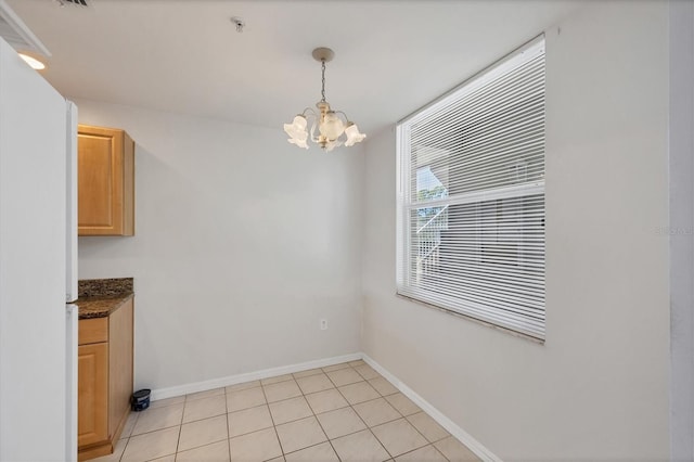 8755 Olde Hickory Ave Unit 7105, Sarasota, FL 34238 - unfurnished dining area with a chandelier, baseboards, and light tile patterned floors