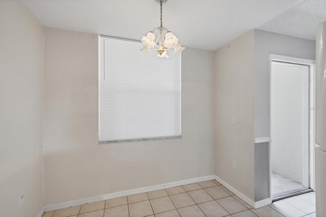 8755 Olde Hickory Ave Unit 7105, Sarasota, FL 34238 - unfurnished dining area with a chandelier, light tile patterned flooring, and baseboards