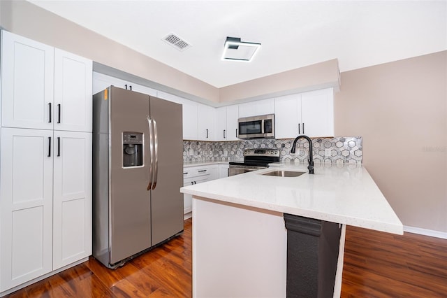 1839 Cranberry Isles Way, Apopka, FL 32712 - kitchen featuring appliances with stainless steel finishes, a peninsula, a sink, white cabinets, and dark wood-type flooring