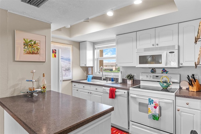 1355 Rock Dove Ct Unit 1-2, Punta Gorda, FL 33950 - kitchen with white appliances, a sink, dark countertops, white cabinetry, and a textured ceiling