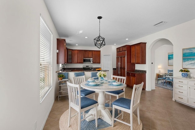 4429 67th St E, Bradenton, FL 34203 - dining area featuring arched walkways, light tile patterned flooring, recessed lighting, and baseboards